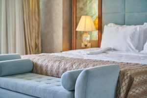 Wystrój pokoju hotelowego – jakie korzyści przyniesie nam szafa drewniana z lustrem?